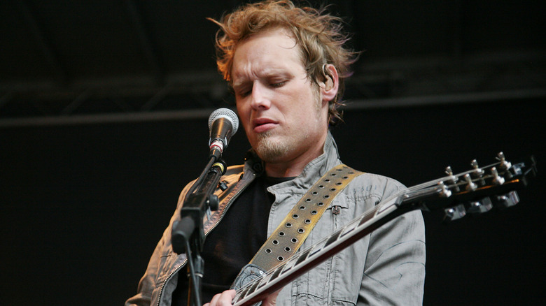 Matt Roberts playing guitar on stage with Three Doors Down