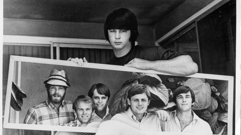 The rock and roll band "The Beach Boys" are reflected in a mirror held by their producer and founder Brian Wilson, circa 1967