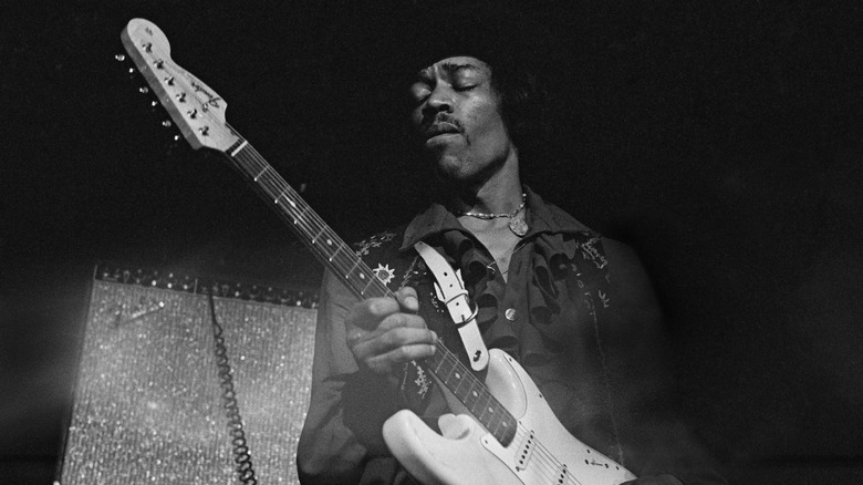Jimi Hendrix playing guitar on stage