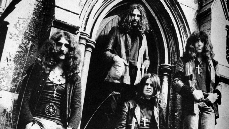 Black Sabbath posing near church