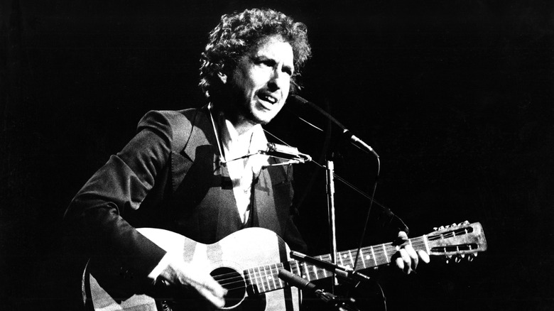 Bob Dylan playing guitar and singing