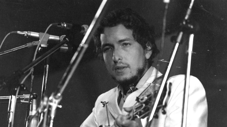 Bob Dylan playing guitar in concert