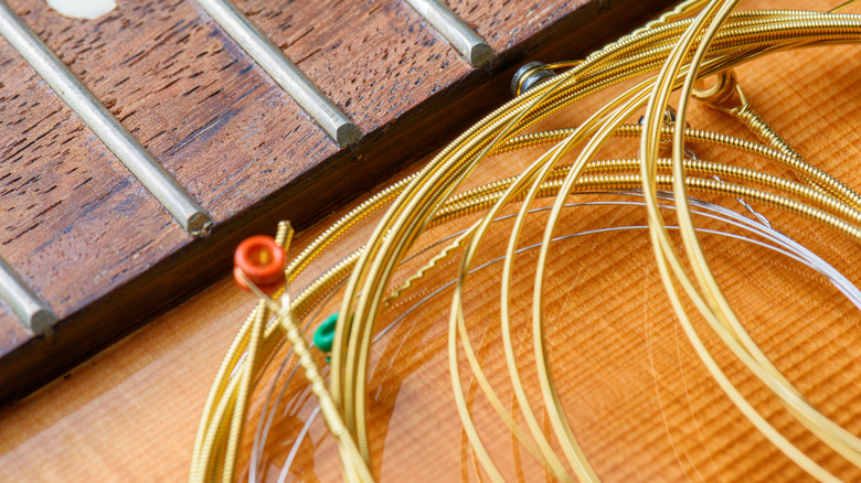 Spare guitar strings near a guitar neck