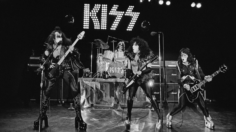 Kiss playing on stage in costume and face paint in the '70s