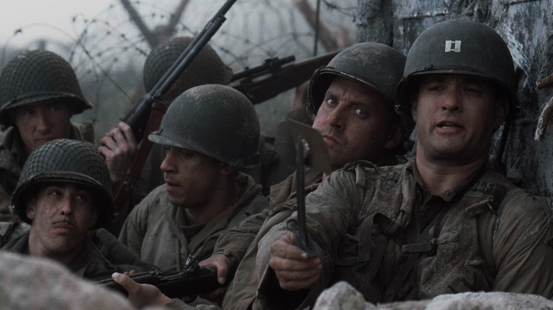 Cast members in Saving Private Ryan using mirror to look over edge of trench