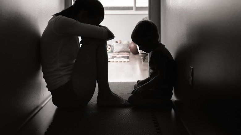 Grieving mother and son in hallway