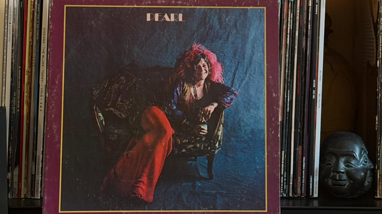 A vinyl copy of Janis Joplin's album "Pearl" leaning on a shelf of records.