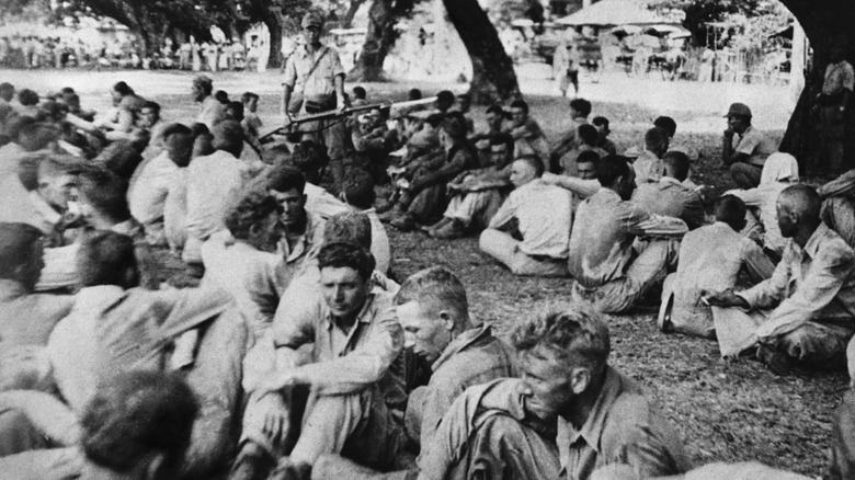 Captured US soldiers seated outside after the Battle of Bataan