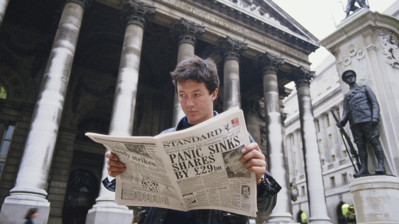man reads newspaper about 1987 stock market crash