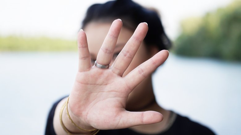 Woman hiding behind hand