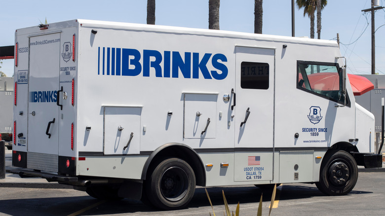 Brink's armored truck parked inf front of palm trees