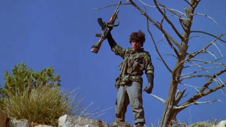 screenshot of teenager brandishing rifle