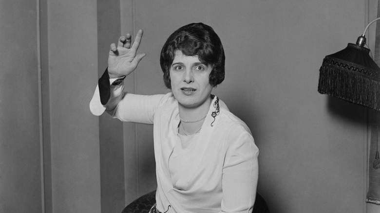 Aimee Semple McPherson posing with hand up, 1927