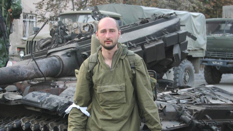 Arkady Babchenko standing in front of ruined tank, August 2008