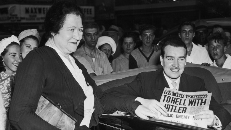 William Patrick Hitler and mother Bridget Hitler. William is holding newspaper headline 