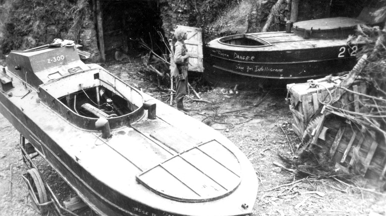 U.S. Marine inspecting two shinyo explosive boats in Okinawa, 1945