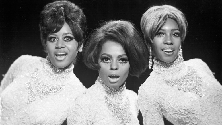 The Supremes smiling in white dresses