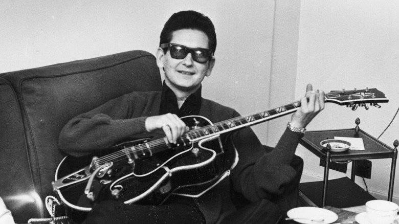 Roy Orbison on couch playing guitar