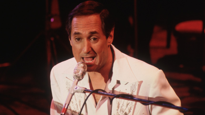 Neil Sedaka singing and playing piano onstage in the 1970s