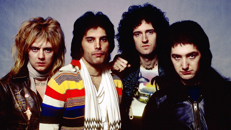 Roger Taylor, Freddie Mercury, Brian May and John Deacon of Queen pose with one another