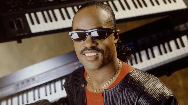 Stevie Wonder posing among keyboards