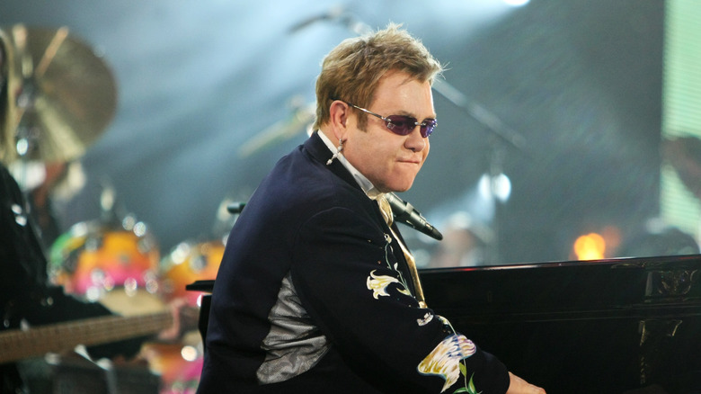 Elton John playing piano and looking at crowd