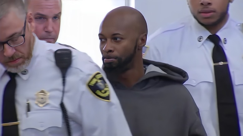 Murder suspect grey hoodie with police