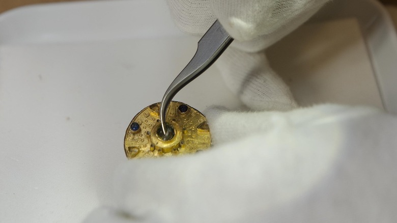 A researcher examines the gold brooch found in Basel