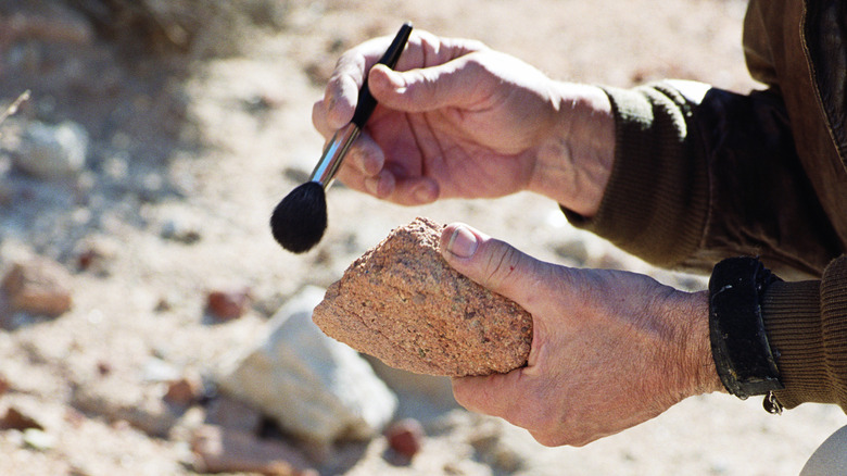 An archeologist brushes off a fragment of a ruin