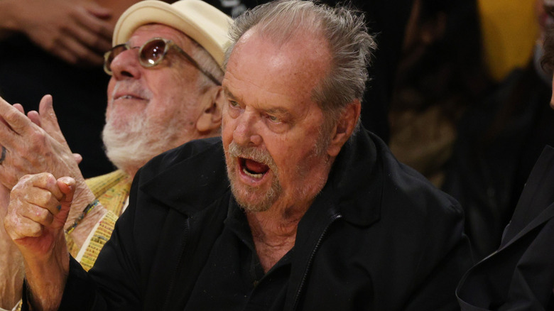 Jack Nicholson shouting fist raised sat at game