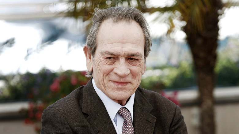 Tommy Lee Jones posing in front of a palm tree