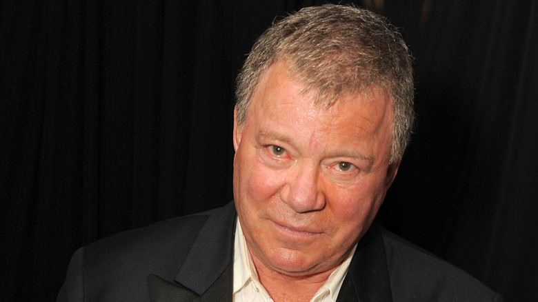 Close up of William Shatner in front of a black curtain