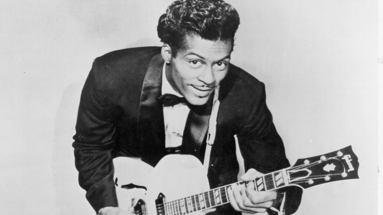 Chuck Berry wearing suit posing with guitar
