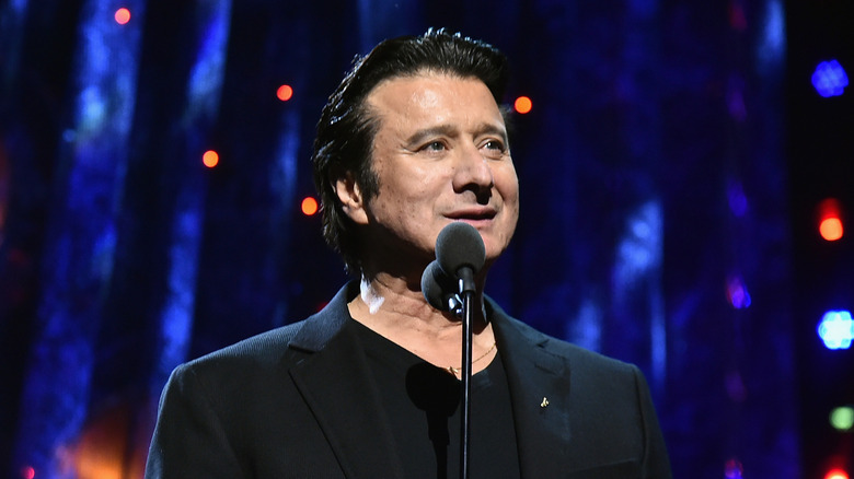 Steve Perry in dark shirt onstage with microphone