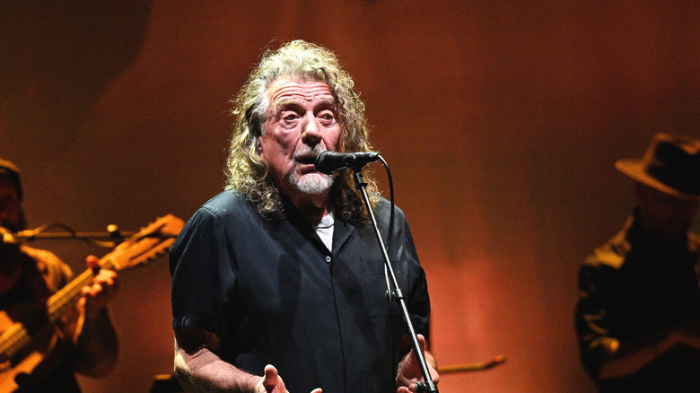 Robert Plant in dark shirt onstage with microphone