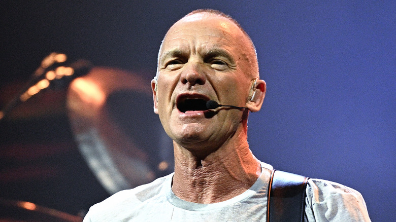 Sting singing onstage into wireless headset mic