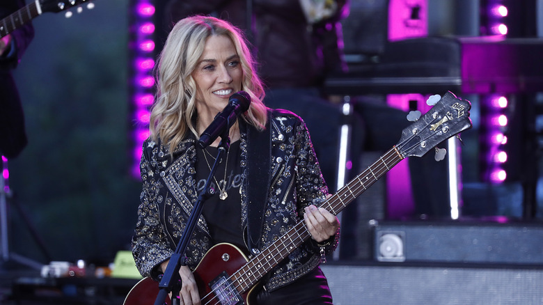 Sheryl Crow playing bass guitar onstage