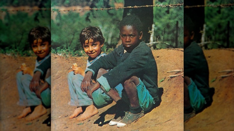 Cover art for Clube da Esquina by Milton Nascimento and Lô Borges, depicting two boys sitting on a dirt road