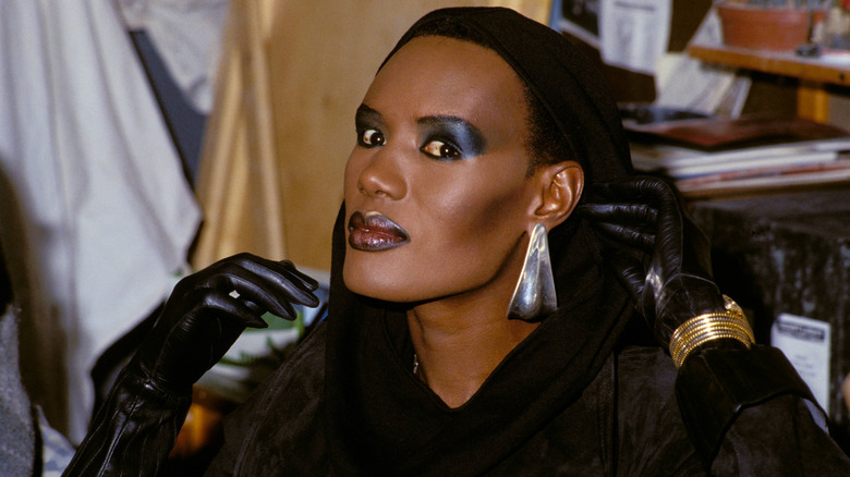 Grace Jones wearing a black gloves and large earrings