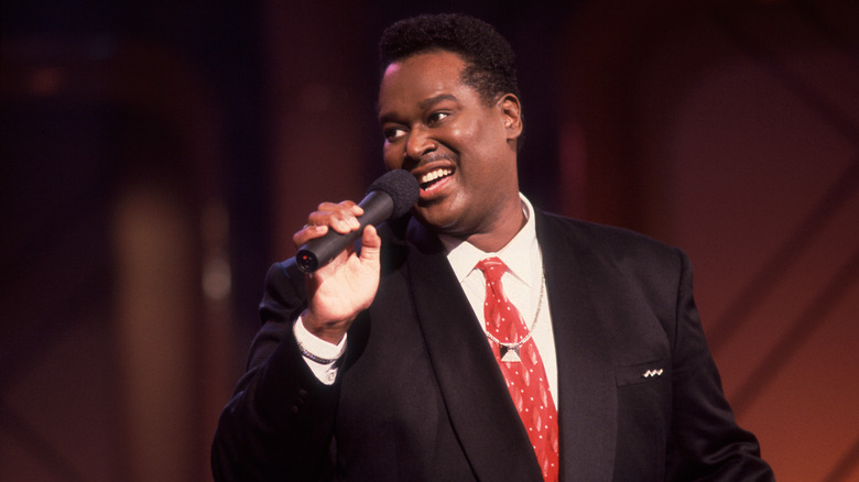Luther Vandross singing into microphone in suit