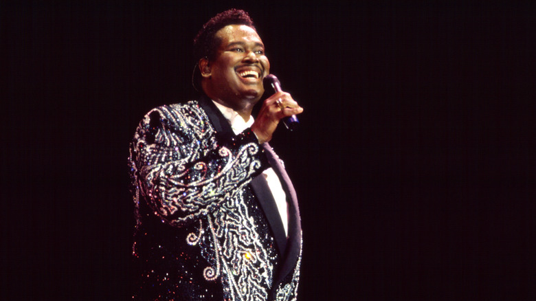 Luther Vandross singing into a microphone in concert