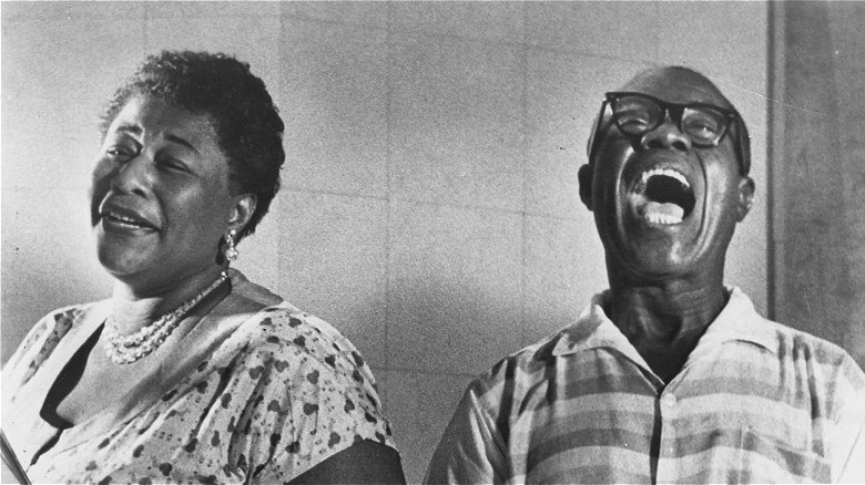 Ella Fitzgerald and Louis Armstrong standing side by side and laughing