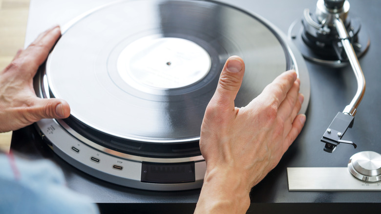 hands placing record on turntable