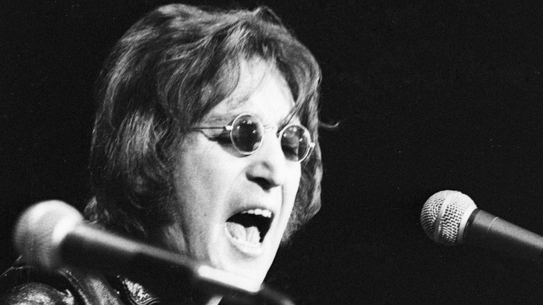 John Lennon onstage with guitar and microphone