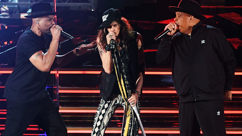 D.M.C., Steven Tyler, and Run performing on stage.