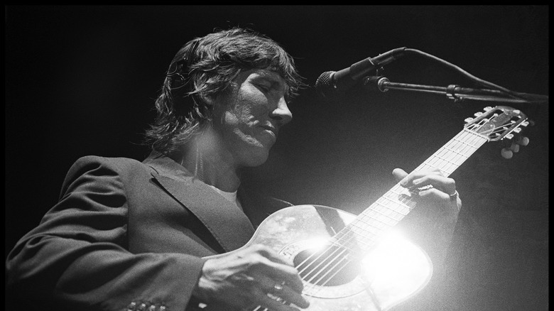 Roger Waters playing guitar on stage
