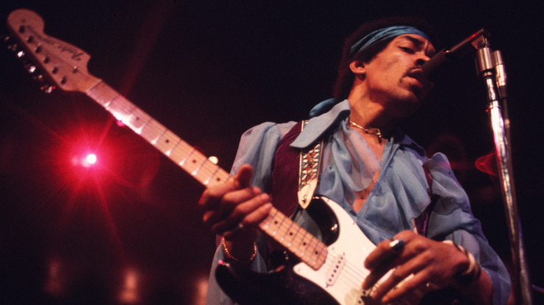 Jimi Hendrix onstage with microphone and guitar