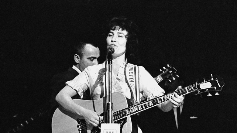 Loretta Lynn on stage playing guitar