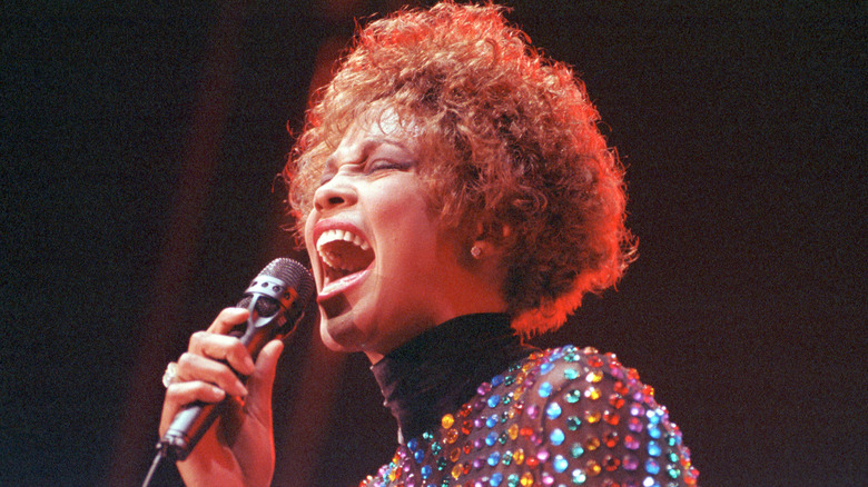 Whitney Houston performs onstage wearing a sequined outfit