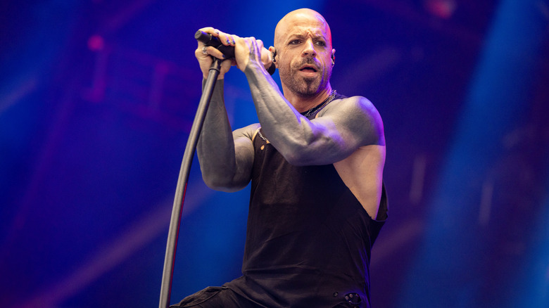 Chris Daughtry braced against a mic on stage